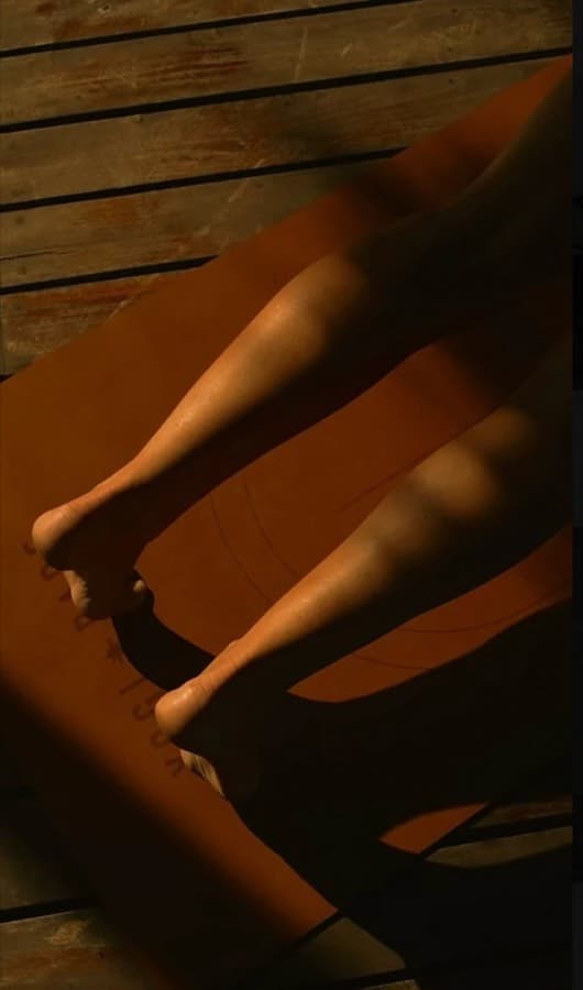 Jambes en mouvement sur un tapis de yoga orange, lumière chaude